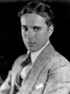 Portrait photographique en noir et blanc d'un jeune homme, habill d'un costume, coiff avec une raie au mileu